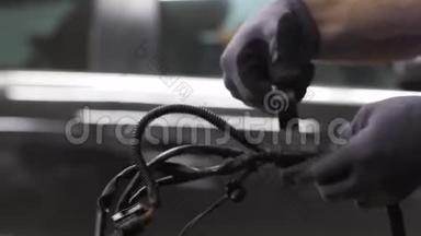 电工在汽车上用电挡工作. 汽车在引擎盖下的内部特写。 <strong>服务人员</strong>的手